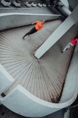 Modern bir şehir ortamında koşan spor elbiseli iki kadın. Sportif ve sağlıklı yaşam tarzı kavramı. 