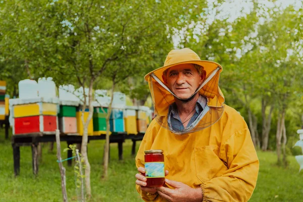 Бджоляр Тримає Банку Меду Руці Стоячи Лузі Оточеному Коробкою Медовою — стокове фото