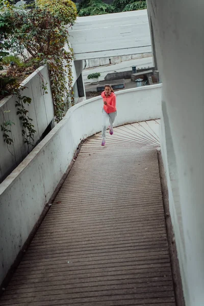 穿着运动服的妇女在现代城市环境中跑步 运动和健康生活方式的概念 — 图库照片