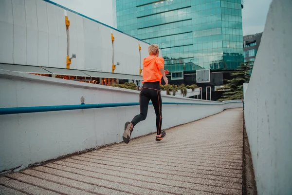 stock image Women in sports clothes running in a modern urban environment. The concept of a sporty and healthy lifestyle. 