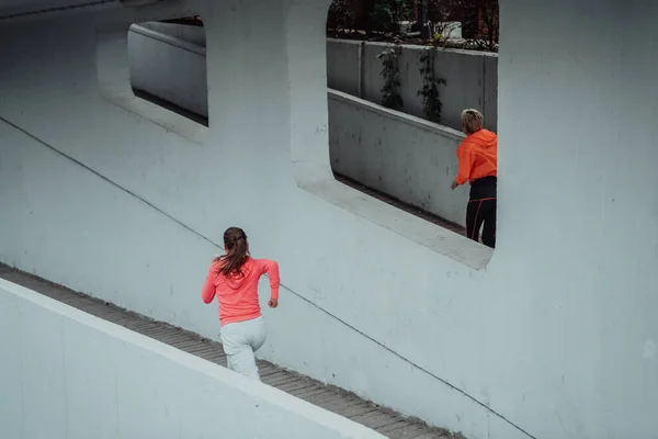 Δύο Γυναίκες Αθλητικά Ρούχα Τρέχουν Ένα Σύγχρονο Αστικό Περιβάλλον Έννοια — Φωτογραφία Αρχείου
