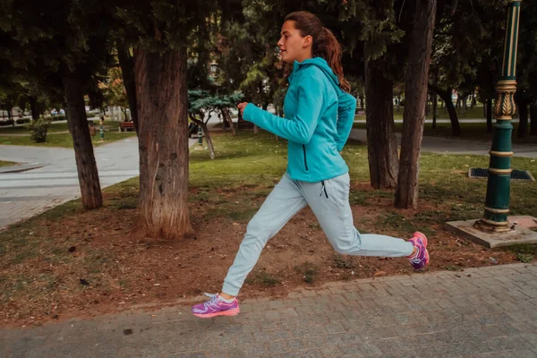 穿着运动服的妇女在现代城市环境中跑步 运动和健康生活方式的概念 — 图库照片