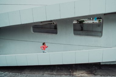 Modern bir şehir ortamında spor elbiseli kadınlar koşuyor. Sportif ve sağlıklı yaşam tarzı kavramı. 