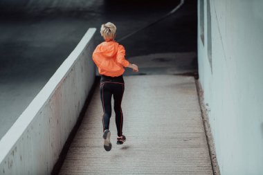 Modern bir şehir ortamında spor elbiseli kadınlar koşuyor. Sportif ve sağlıklı yaşam tarzı kavramı. 