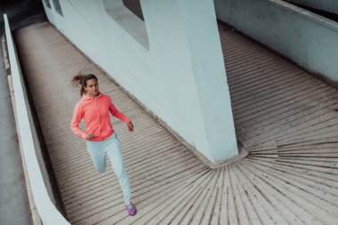 Modern bir şehir ortamında spor elbiseli kadınlar koşuyor. Sportif ve sağlıklı yaşam tarzı kavramı. 