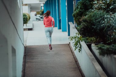 Women in sports clothes running in a modern urban environment. The concept of a sporty and healthy lifestyle. 