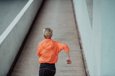 Women in sports clothes running in a modern urban environment. The concept of a sporty and healthy lifestyle. 