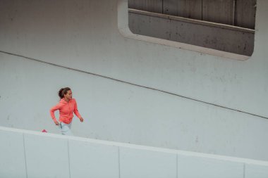 Modern bir şehir ortamında spor elbiseli kadınlar koşuyor. Sportif ve sağlıklı yaşam tarzı kavramı. 