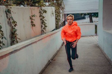 Women in sports clothes running in a modern urban environment et night time. The concept of a sporty and healthy lifestyle. 