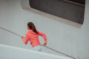 Women in sports clothes running in a modern urban environment. The concept of a sporty and healthy lifestyle. 