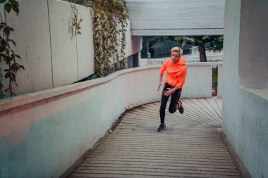 Women in sports clothes running in a modern urban environment et night time. The concept of a sporty and healthy lifestyle. 