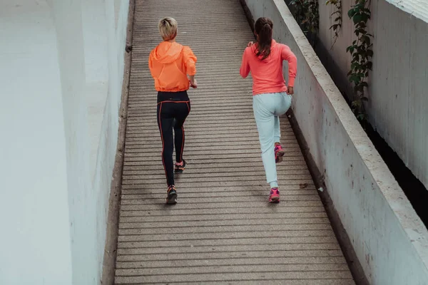Dvě Ženy Sportovním Oblečení Běhají Moderním Městském Prostředí Koncept Sportovního — Stock fotografie