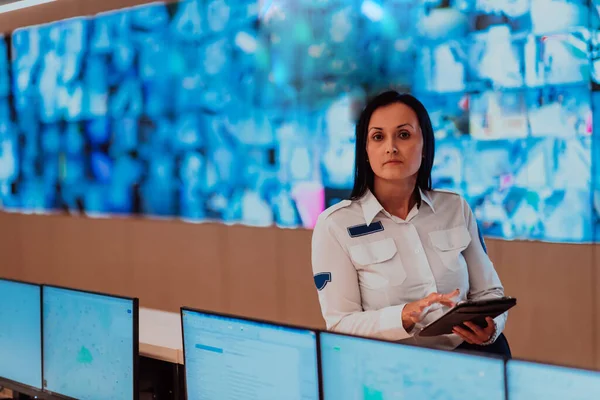 データシステム制御室オフィスで働く女性セキュリティ担当者技術担当者複数のディスプレイでワークステーションで作業 複数のモニターで働くセキュリティガード — ストック写真