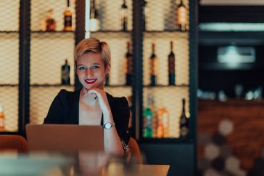 Businesswoman sitting in a cafe while focused on working on a laptop and participating in an online meetings. Selective focus