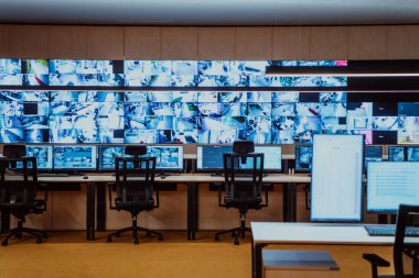 Büyük, modern güvenlik kontrol odasının içi boş, birden fazla ekranı olan çalışma istasyonu, güvenlik veri merkezindeki izleme odası boş ofis, masa ve ana CCTV güvenlik verilerindeki sandalyeler.