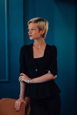 Blonde business woman, successful confidence on modern blue mat background. Selective focus. 