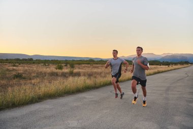 Gün doğumunun erken saatlerinde birlikte koşan bir grup yakışıklı adam fitness, zindelik ve canlılığın özünü somutlaştırıyor ve doğalarını kucaklayan huzurun canlandırıcı neşesini somutlaştırıyorlar.
