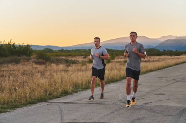 Gün doğumunun erken saatlerinde birlikte koşan bir grup yakışıklı adam fitness, zindelik ve canlılığın özünü somutlaştırıyor ve doğalarını kucaklayan huzurun canlandırıcı neşesini somutlaştırıyorlar.