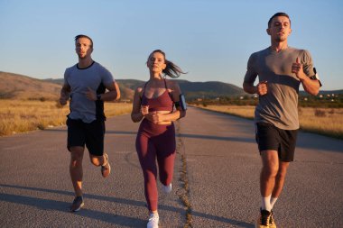 Gün doğumunun erken saatlerinde birlikte koşan bir grup genç sporcu kolektif enerjilerini, kararlılıklarını ve birliklerini sergilediler. .