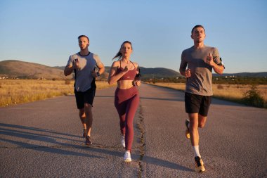 Gün doğumunun erken saatlerinde birlikte koşan bir grup genç sporcu kolektif enerjilerini, kararlılıklarını ve birliklerini sergilediler. .