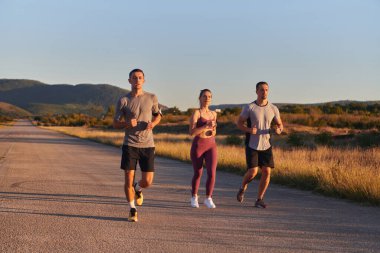 Gün doğumunun erken saatlerinde birlikte koşan bir grup genç sporcu kolektif enerjilerini, kararlılıklarını ve birliklerini sergilediler. .
