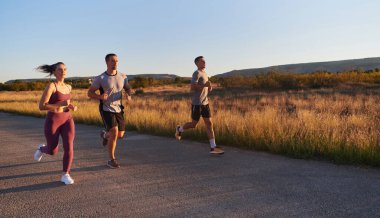 Gün doğumunun erken saatlerinde birlikte koşan bir grup genç sporcu kolektif enerjilerini, kararlılıklarını ve birliklerini sergilediler. .