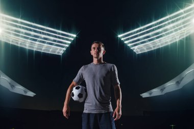 Sokakta futbol topuyla oynayan yakışıklı bir futbolcunun portresi.