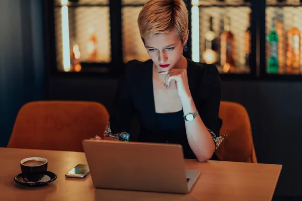 女商人坐在咖啡店里 专心致志地工作在笔记本电脑上 参加在线会议 有选择的重点 — 图库照片