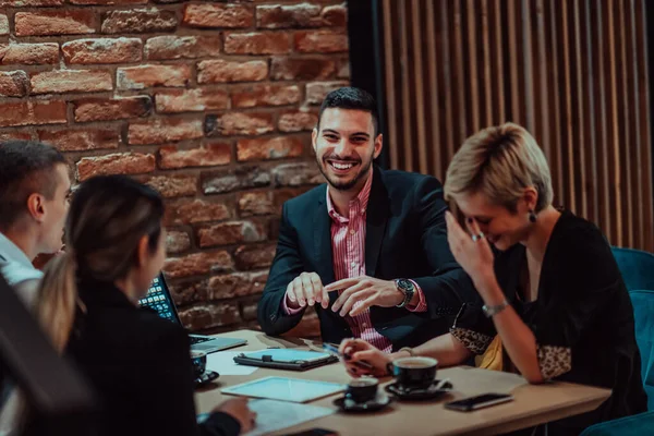 stock image Happy businesspeople smiling cheerfully during a meeting in a coffee shop. Group of successful business professionals working as a team in a multicultural workplace. 