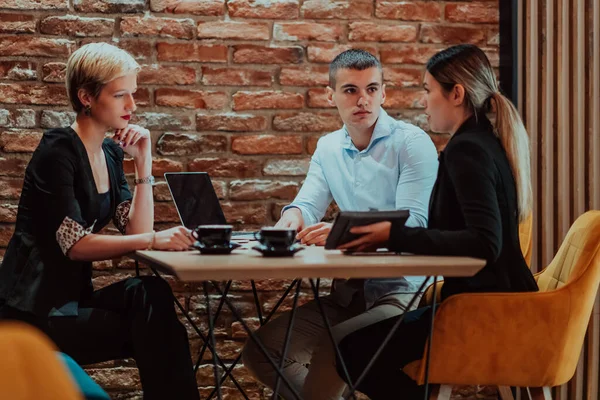 stock image Happy businesspeople smiling cheerfully during a meeting in a coffee shop. Group of successful business professionals working as a team in a multicultural workplace. 