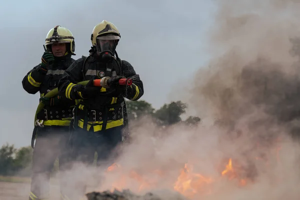 stock image Firefighters fight the fire flame to control fire not to spreading out. Firefighter industrial and public safety concept. Traffic or car accident rescue and help action