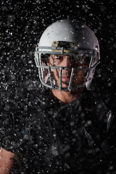 アメリカンフットボールフィールド 戦場に立つロンリーアスリート戦士ヘルメットを保持し プレイする準備ができています プレーヤータッチダウンを実行 およびスコアする準備をします 劇的な霧と雨の夜 青の光 — ストック写真