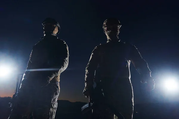 危険な任務の夜の暗闇の中を行進する2人のプロの兵士は 彼らの揺るぎない勇気 揺るぎないチームワーク そして彼らの専門分野の高ステークス強度を象徴しています — ストック写真