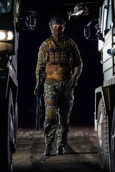 A soldier marching through the dark of night, accompanied by two military trucks, as he embarks on a perilous military mission, embodying the unwavering determination, teamwork, and preparedness