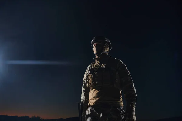 一名身穿全套军服的职业军人在漆黑的夜晚艰难地执行着危险的军事任务 — 图库照片