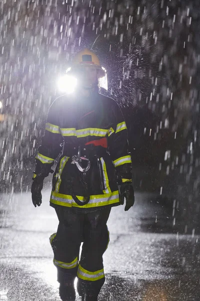 Zdeterminowana Strażaczka Profesjonalnym Mundurze Krocząca Przez Niebezpieczną Deszczową Noc Śmiałej — Zdjęcie stockowe