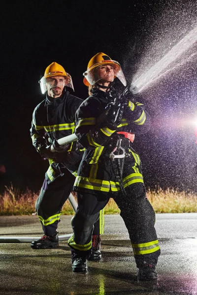 Firefighters Using Water Hose Eliminate Fire Hazard Team Female Male — Stock Photo, Image