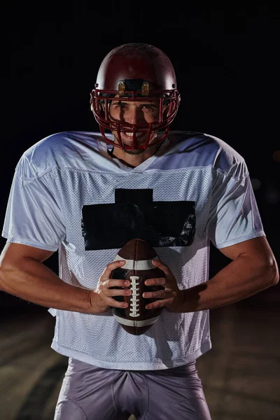 American Football Field: Lonely Athlete Warrior Standing on a Field Holds his Helmet and Ready to Play. Player Preparing to Run, Attack and Score Touchdown