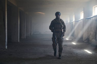 Terk edilmiş bir binada profesyonel bir asker, bir savaş kampanyasında cesaret ve kararlılık gösteriyor.. 