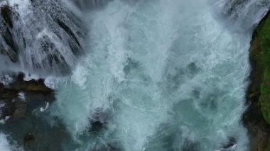 Bosna-Hersek 'te büyük bir şelaleyle vahşi nehrin destansı görüntüsünü oluşturan şaşırtıcı yavaş çekim. Kristal berrak içme suyu güzel şelale bulutlu yaz gününde.