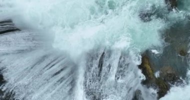 Bosna-Hersek 'te büyük bir şelaleyle vahşi nehrin destansı görüntüsünü oluşturan şaşırtıcı yavaş çekim. Kristal berrak içme suyu güzel şelale bulutlu yaz gününde.