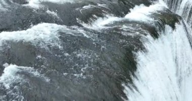 Bosna-Hersek 'te büyük bir şelaleyle vahşi nehrin destansı görüntüsünü oluşturan şaşırtıcı yavaş çekim. Kristal berrak içme suyu güzel şelale bulutlu yaz gününde.