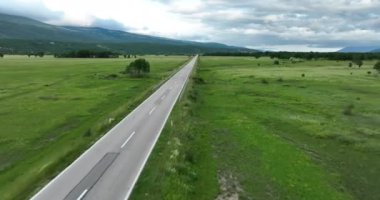 Yaz bulutlu bir günde güzel bir çayır doğasında boş bir kır yolunun hava görüntüsü.. 