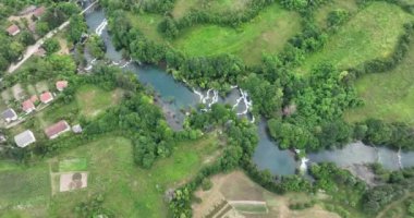 Bosna-Hersek 'te büyük bir şelaleyle vahşi nehrin destansı görüntüsünü oluşturan şaşırtıcı yavaş çekim. Kristal berrak içme suyu güzel şelale bulutlu yaz gününde.