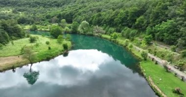 Bosna-Hersek 'te büyük bir şelaleyle vahşi nehrin destansı görüntüsünü oluşturan şaşırtıcı yavaş çekim. Kristal berrak içme suyu güzel şelale bulutlu yaz gününde.
