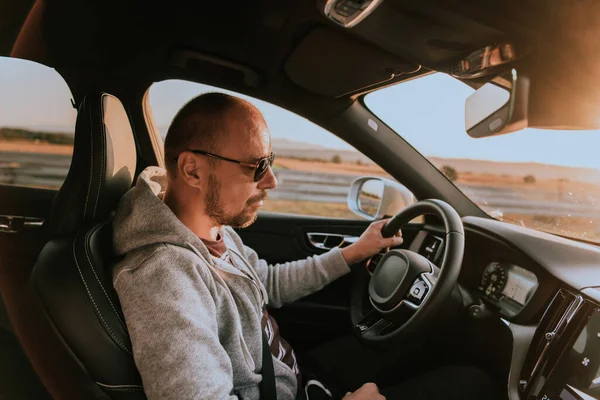 Een Man Met Een Zonnebril Die Bij Zonsondergang Een Auto — Stockfoto