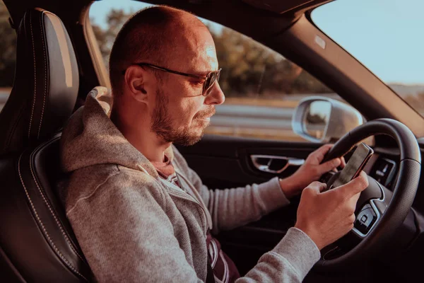 Muž Slunečními Brýlemi Řídí Auto Při Západu Slunce Napíše Zprávu — Stock fotografie