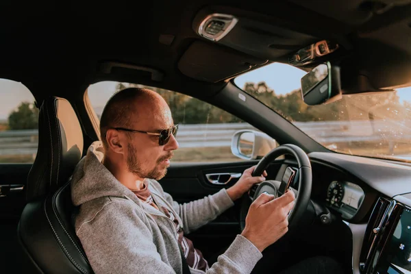 Homem Com Óculos Sol Dirigindo Carro Digite Uma Mensagem Smartphone — Fotografia de Stock