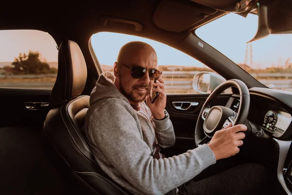Een Man Met Een Zonnebril Rijdt Een Auto Praat Smartphone — Stockfoto