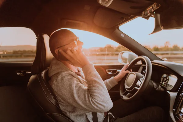 Человек Солнечных Очках Водит Машину Разговаривает Смартфону Закате Концепция Автомобильных — стоковое фото